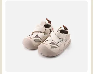 Detailed view of beige toddler closed-toe sandals with mesh panels and MBX logo on toe.