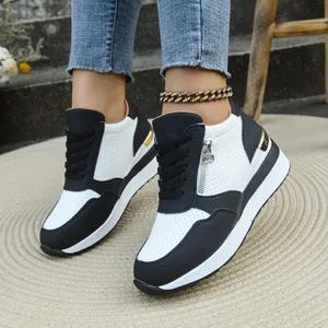 Primo piano di sneakers con zeppa da donna bianche e nere con zip laterale