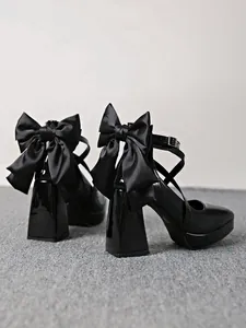 Back view detail of black patent leather pumps with oversized satin bow and block heel