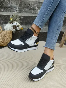 Vista dettagliata delle sneakers platform da donna bianche e nere con lacci e cerniera