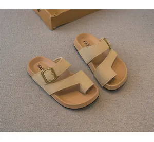 Vista dettagliata di sandali infradito beige per bambini con fibbie decorative