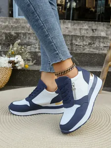 Dettaglio laterale delle sneakers con zeppa blu e bianche da donna con cerniera