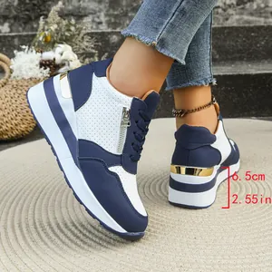 Dettaglio di sneakers con zeppa blu e bianche per donna con tacco alto 6,5 cm.