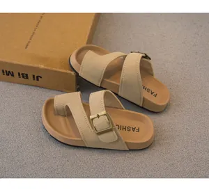 Dettaglio delle scarpe sandali beige per bambini con fibbie retrò e design a infradito