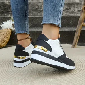 Vista posteriore di sneaker platform bianche e nere con accenti metallici dorati.