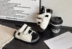 Vue détaillée de sandales stylées pour enfants noir et blanc avec bandes velcro.
