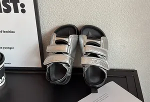 Vue détaillée des sandales de plage argentées pour enfants avec bandes Velcro.