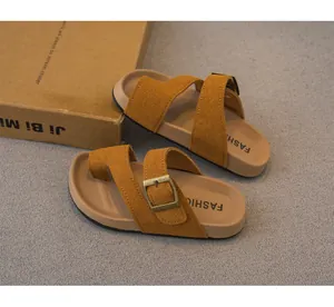 Dettaglio dei sandali vintage in pelle scamosciata marrone per bambina con fibbia e anello