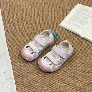 Children's pink closed-toe outdoor sport sandals on a warm neutral textured rug