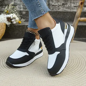 Vista dettagliata di sneaker con zeppa bianche e nere da donna con trafori