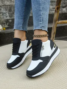 Vista dettagliata di sneaker con zeppa da donna in bianco e nero con cerniera laterale