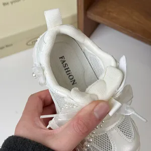 Vista ravvicinata di sneaker bianca da principessa per bambina con nastro di perle e rete