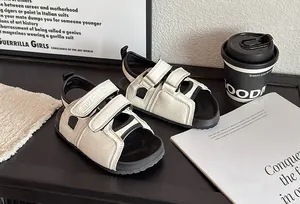 Détail de sandales blanches pour enfants à bout ouvert sur bois foncé