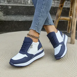 Dettaglio scarpe da ginnastica zeppa blu e bianche con cerniera laterale e design stringato