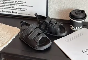 Gros plan sur des sandales de plage noires pour enfants avec sangles réglables.