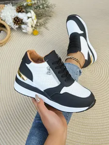 Eleganti sneakers con zeppa interna da donna nere e bianche con dettagli in oro.
