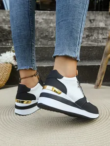 Dettaglio ravvicinato di sneaker platform bianche e nere da donna con accenti oro