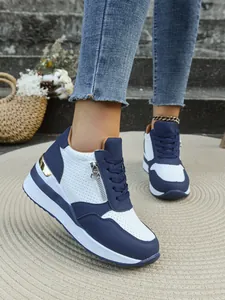 Vista dettagliata di sneaker con zeppa blu navy e bianche con cerniera laterale