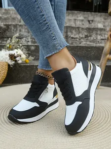 Dettaglio delle sneakers con zeppa bianche e nere da donna con lacci