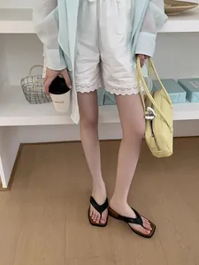 Vue détaillée de tongs à plateforme noires et élégantes pour femmes en tenue d'été chic
