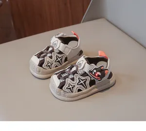 Close-up detail of toddler sandals featuring glowing cartoon eyes and star patterns.