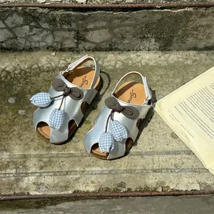 Detail view of silver girl's sandals with cute tulip and bow accents