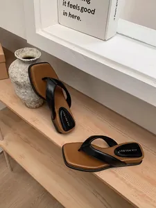 Vue détaillée de tongs tendance pour femmes avec semelles épaisses et bout carré chic.