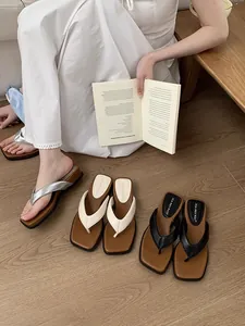 Sandales tongs à plateforme pour femmes en argent, blanc et noir sur sol en bois