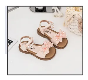 Detailansicht rosa Mädchensandalen mit Netzschleife und Perlenverzierung.