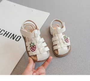 Detail view of cream girls strawberry sandals with soft sole and hook-and-loop strap