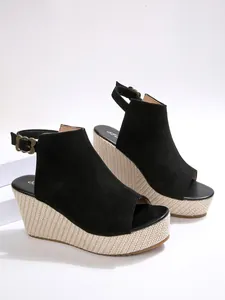 Schwarze Peeptoe-Sandaletten mit hohem Keilabsatz aus geflochtenem Stroh-Material.