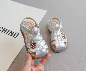 Silver metallic girls sandals featuring a cute strawberry patch and protective caged toe design.