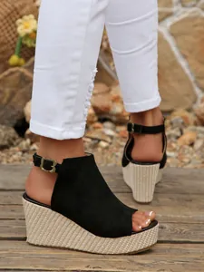 Detailansicht der schwarzen Peep-Toe Keilsandaletten mit Plateausohle und Herzschnalle