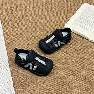 Détail rapproché de sandales en maille respirante pour enfants en noir et blanc avec bout fermé