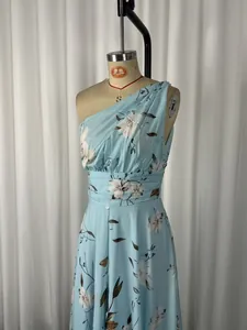 Détail d'une robe élégante en mousseline à une épaule avec imprimé floral bleu