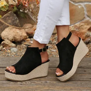 Modische Damen-Keilsandaletten in Schwarz mit Peep-Toe und gewebter Plateausohle.