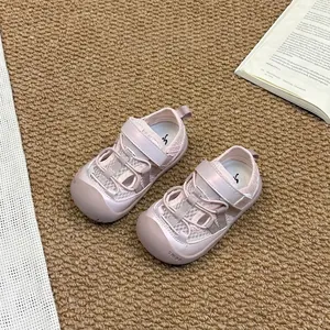 Détail de sandales roses en maille pour enfants avec bande Velcro et bout fermé