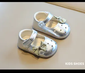 Primer plano de zapatos Mary Jane plateados para bebé con suela blanda y calados de estrellas