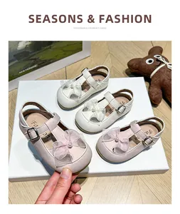Detail view of pink and white children's sandals with bow-knot and pearl accents