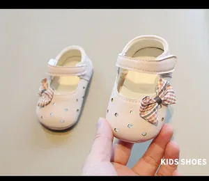 Primer plano de zapatos de bebé rosa para niña con lazo decorativo y diseño calado