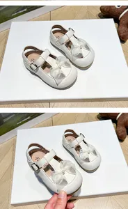 Detailed view of white toddler girl sandals featuring elegant pearl bow design