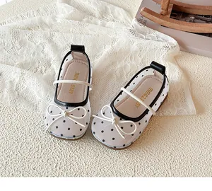 Gros plan de chaussures de princesse en résille à pois pour filles avec nœud sur dentelle.