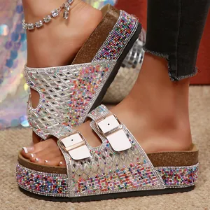 Detailed view of women's platform slides with colorful rhinestone beads and white double buckles