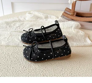 Détail rapproché des chaussures Mary Jane en maille noire à pois pour filles avec nœud