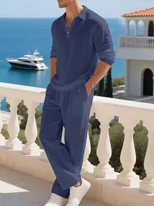Men's navy blue linen outfit worn by a model on a balcony overlooking a scenic ocean view