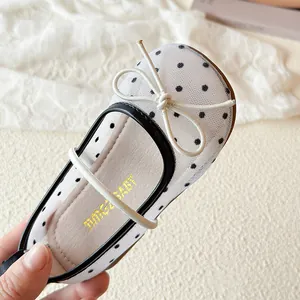 Scarpine da principessa in mesh bianco per bambina con pois neri e fiocco elegante.