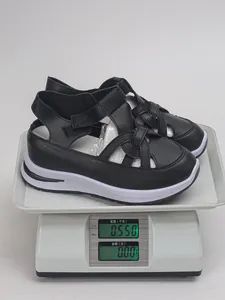 Detailansicht der schwarzen Plateau-Sandalen mit einem Gewicht von 0,550 kg auf Waage