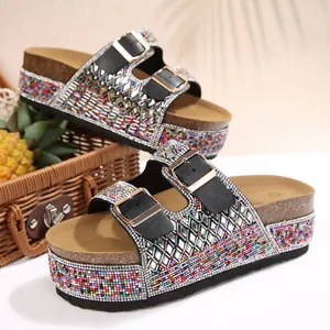 Detailed view of women's platform slides with colorful rhinestones and gold buckles
