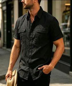 Detail shot of a black short-sleeved jacquard shirt with double chest pockets.