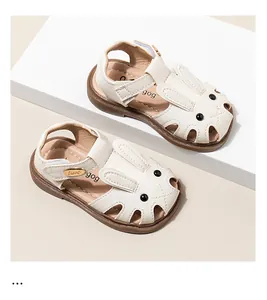 Detalle de sandalias blancas para niños pequeños con orejas de conejo y cierre de velcro